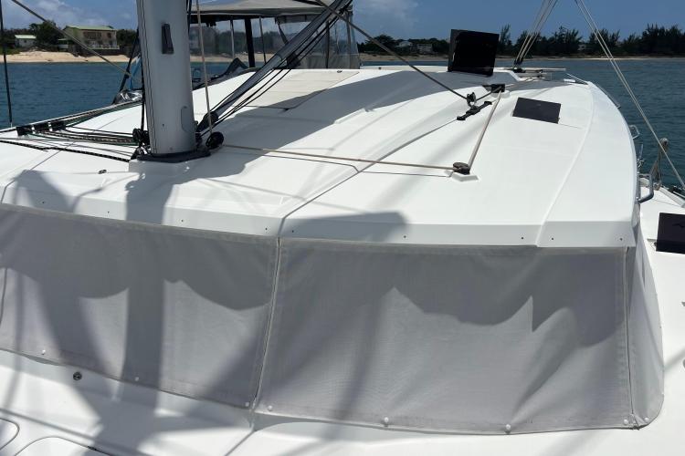 2023 Fountaine Pajot Astrea 42 Catamaran deck with sail rigging, docked by the shore.