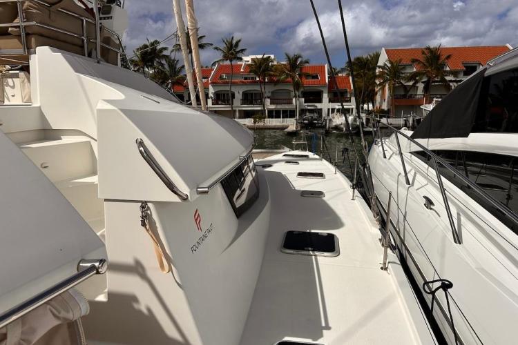 2016 Fountaine Pajot Ipanema 58 catamaran docked near waterfront homes.