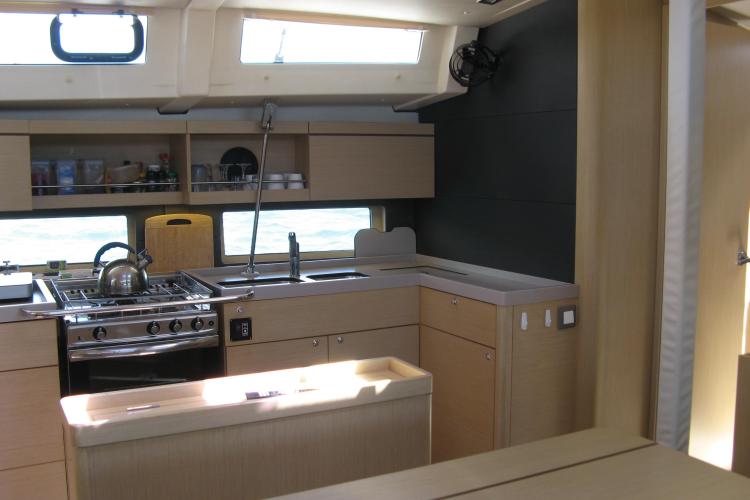 Modern kitchen interior of 2019 Beneteau Oceanis 46.1 yacht with stove and sink.