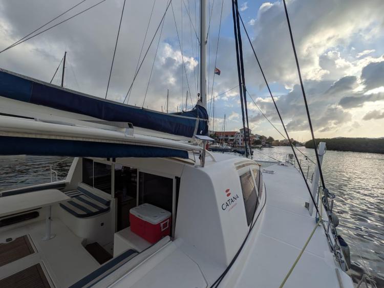 Catana 55 sailboat from 2012 docked at marina under cloudy sky.