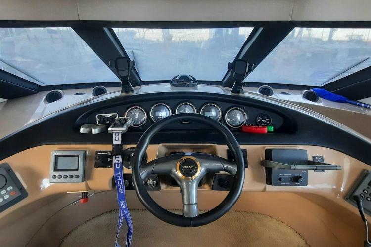 Pilothouse of 2000 Carver 530 Voyager, featuring steering wheel and navigation instruments.