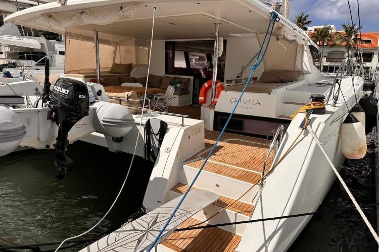 2016 Fountaine Pajot Ipanema 58 catamaran docked, featuring spacious deck and Suzuki outboard motor.
