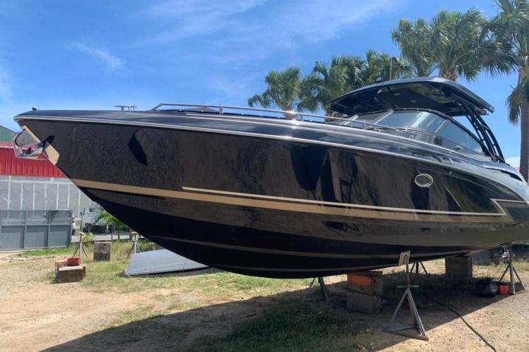 2018 Formula 350 Crossover Bowrider on stands, surrounded by palm trees.