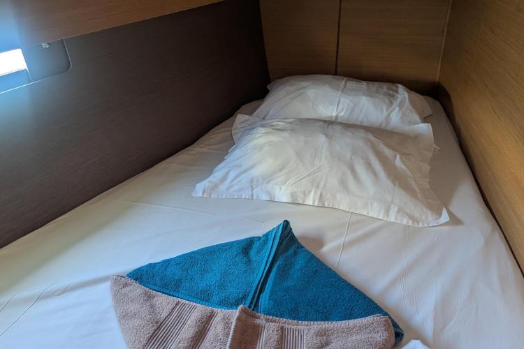 Cozy cabin bed in 2017 Dufour 460 Grand Large yacht with neatly arranged towels.