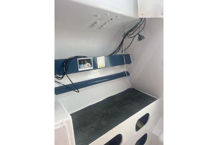 Interior of a 1994 Coulombel Trimaran with wiring and a small shelf.