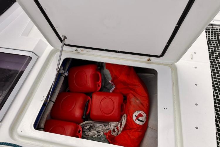 Storage compartment on 2016 Fountaine Pajot Ipanema 58 with red fuel containers and rope.