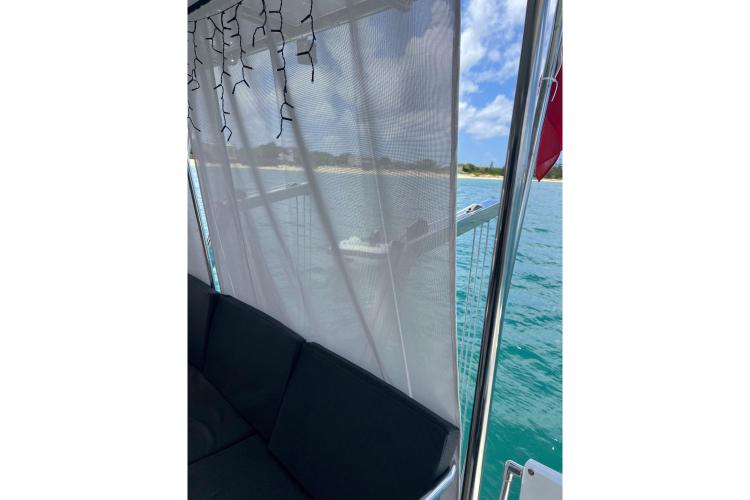 2023 Fountaine Pajot Astrea 42 Catamaran with ocean view through sheer curtains.