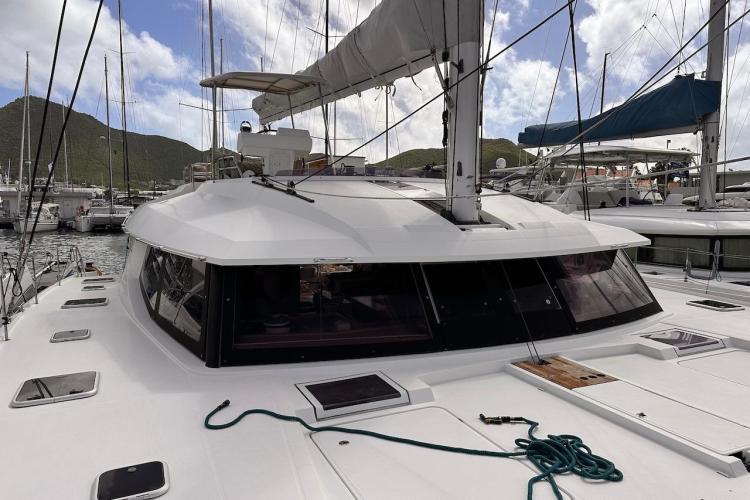 2016 Fountaine Pajot Ipanema 58 catamaran docked in a marina with scenic mountain backdrop.