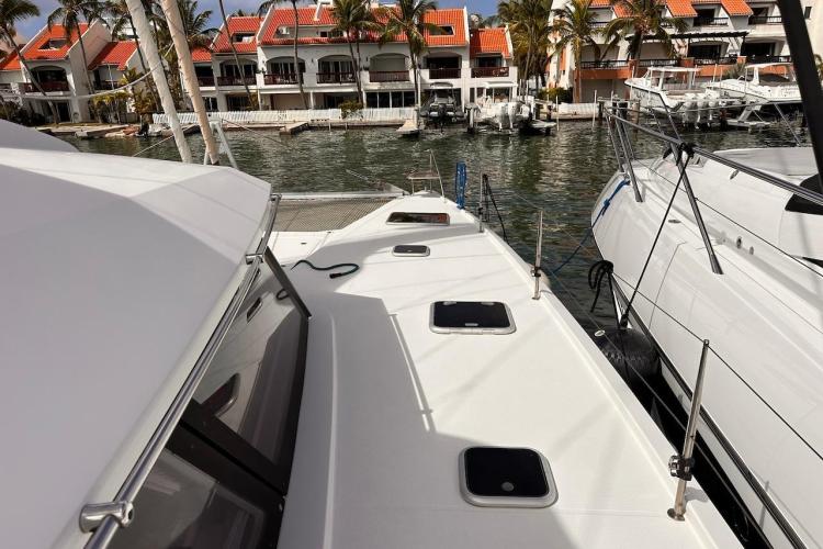 2016 Fountaine Pajot Ipanema 58 catamaran docked near waterfront homes.