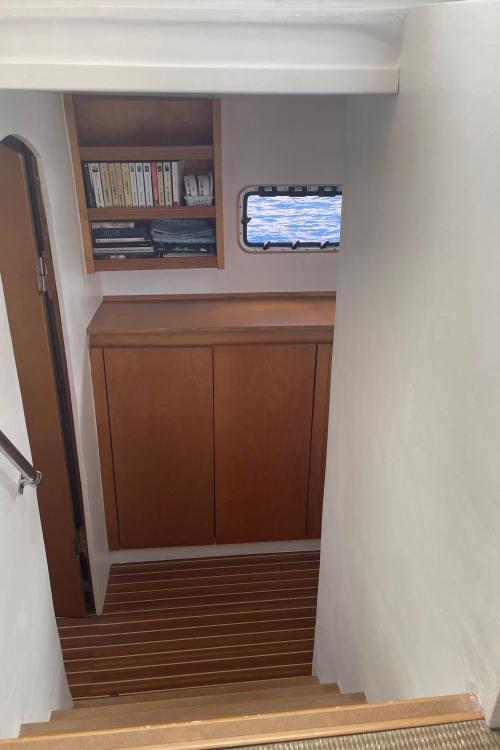 Staircase on Custom KSENIA 149 yacht, featuring wooden cabinets and bookshelves, 2010 model.