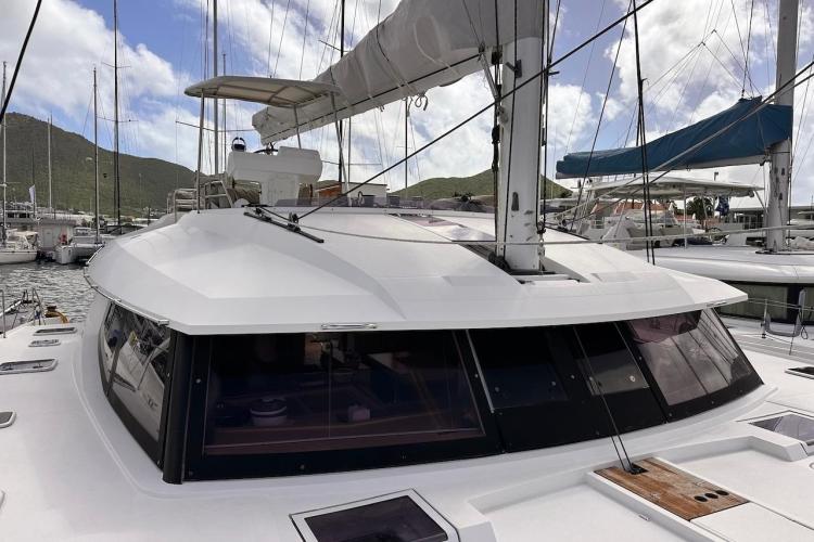 2016 Fountaine Pajot Ipanema 58 catamaran docked at marina with scenic mountain backdrop.
