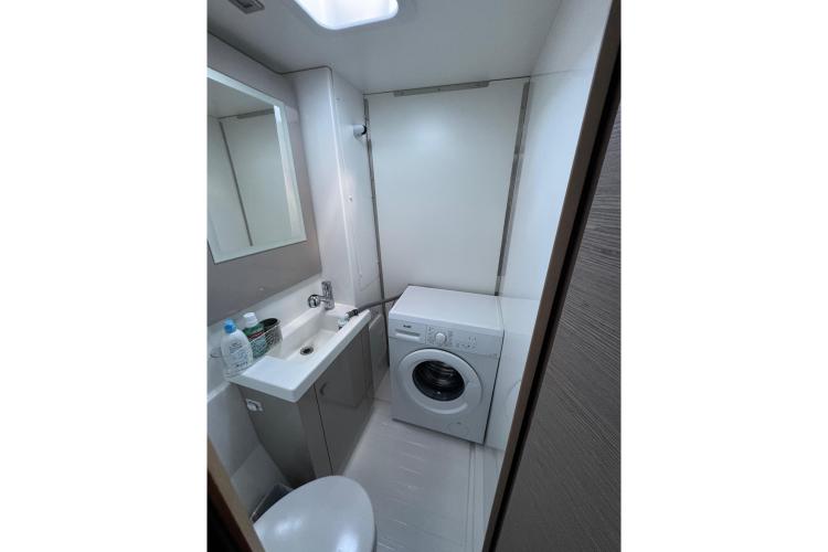 Bathroom with sink and washing machine in 2023 Fountaine Pajot Astrea 42 Catamaran.