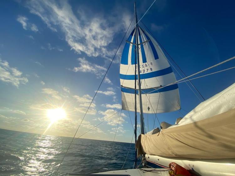 Sailing on a 2006 Fountaine Pajot Bahia 46 catamaran at sunset, ocean view.