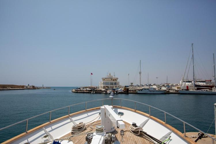 Bow view of 1972 Benetti 33 yacht entering a marina, surrounded by other boats.