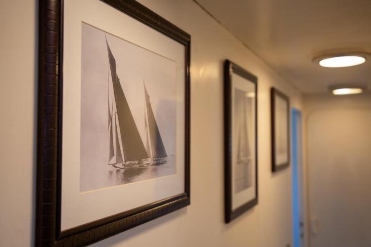 Framed sailboat photographs on Benetti 33 yacht, 1972 model, hallway interior.