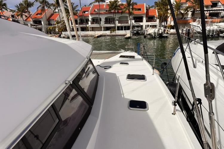 2016 Fountaine Pajot Ipanema 58 catamaran docked near waterfront homes.