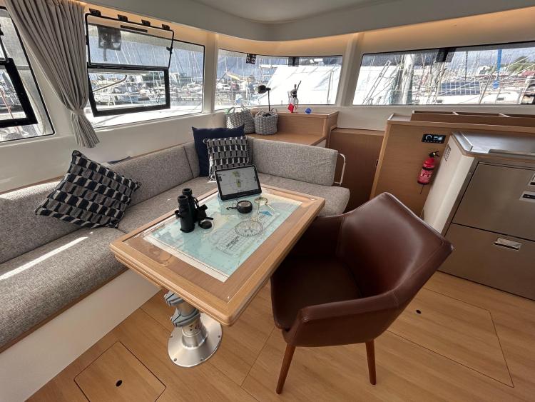 Luxurious interior of 2024 Excess 14 yacht with modern seating and navigation table.