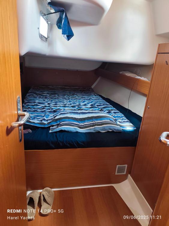 Cozy cabin interior of 2005 Beneteau Cyclades 43.3 yacht with striped bedding.