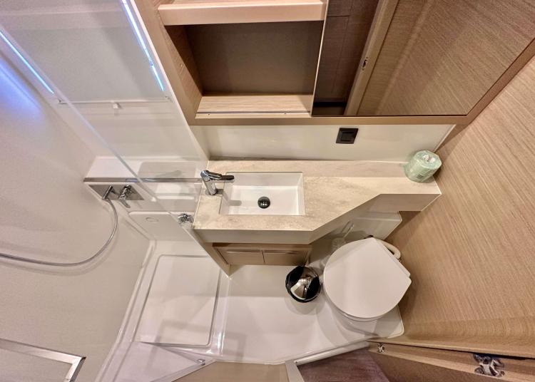 Modern bathroom in 2023 Lagoon 46 yacht with sink, toilet, and shower.