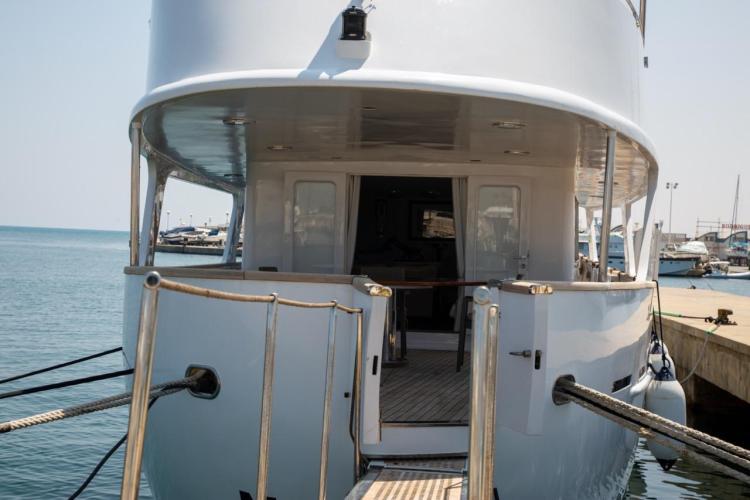 1972 Benetti 33 yacht docked at a marina, rear view with open deck.