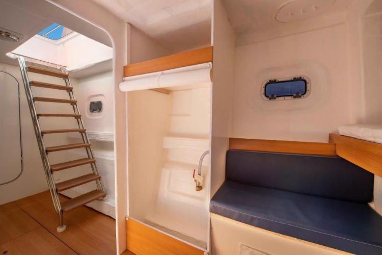 Interior of 2026 Custom DAYCHARTER boat with wooden stairs and seating area.