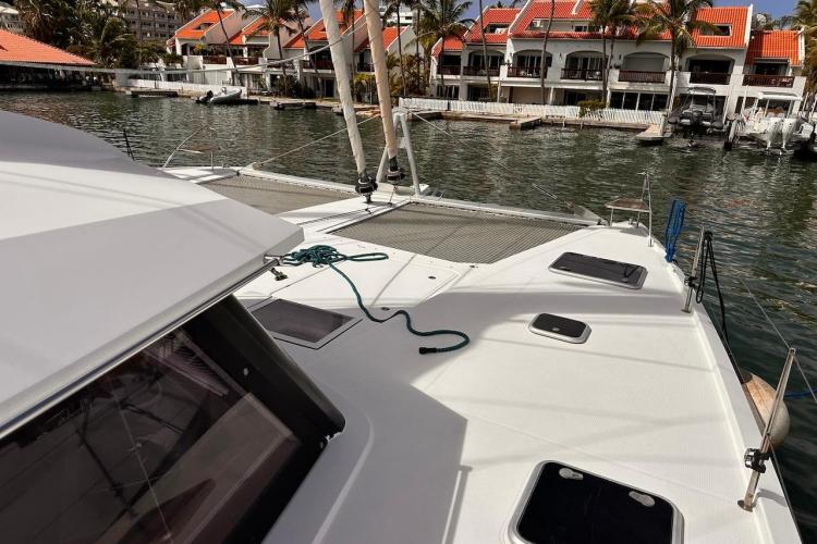2016 Fountaine Pajot Ipanema 58 catamaran docked near waterfront homes.