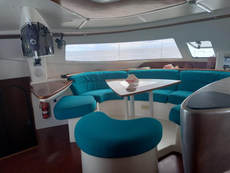 Interior of 1999 Fountaine Pajot Bahia 46 catamaran with turquoise seating and wooden accents.