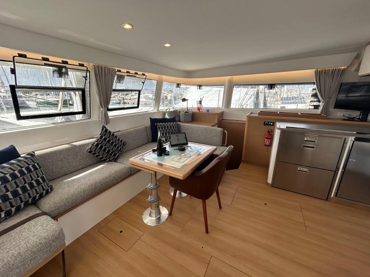 Luxurious interior of 2024 Excess 14 catamaran with modern seating and dining area.