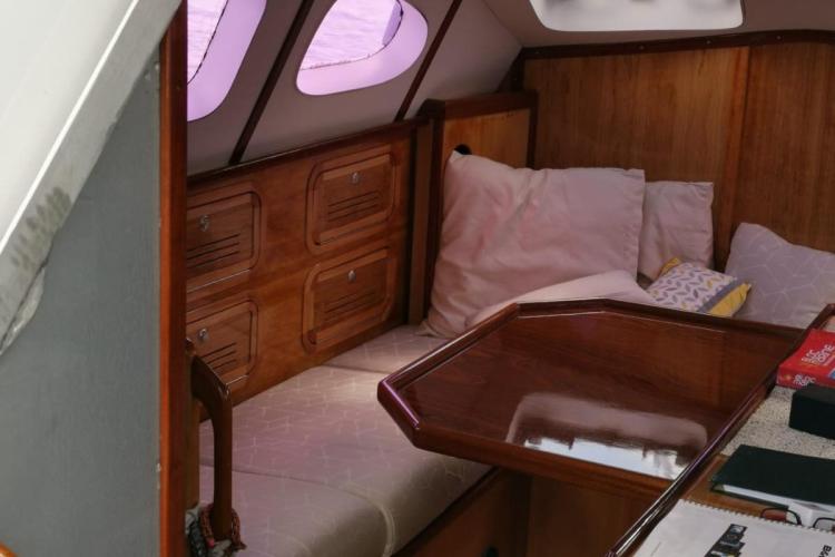 Interior of 2019 Custom Patago 40 yacht with wooden furnishings and cozy seating area.