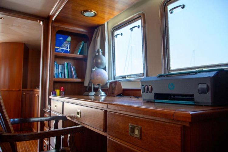 Luxurious interior of 1972 Benetti 33 yacht with wooden desk and printer.