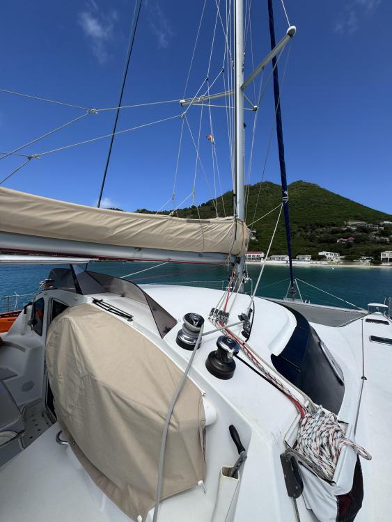 2006 Fountaine Pajot Bahia 46 catamaran with sails, docked near lush green hills.