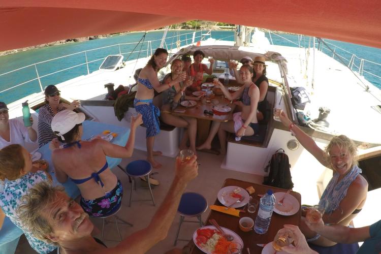 Group enjoying a meal on a 1995 Catamaran Day Charter Open Bridge Deck.