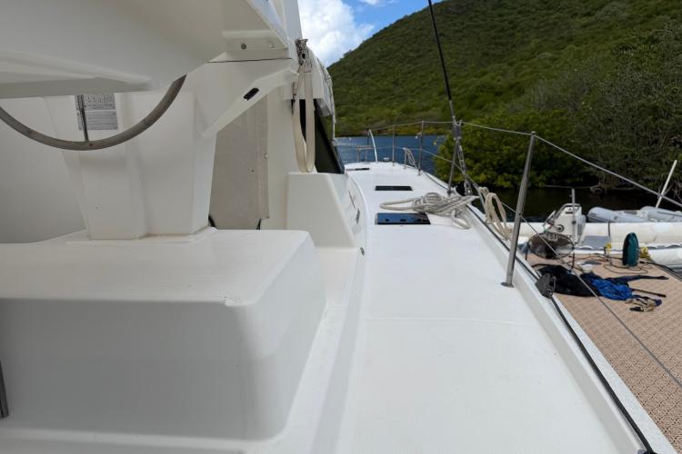 Fountaine Pajot Astrea 42 catamaran deck, 2020 model, docked near lush green hills.