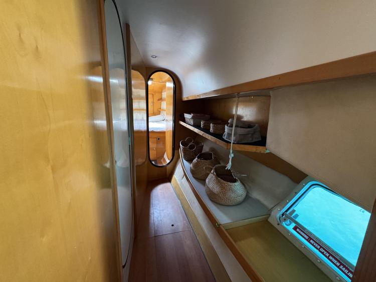 Interior hallway of 2006 Fountaine Pajot Bahia 46 catamaran with storage shelves and window.