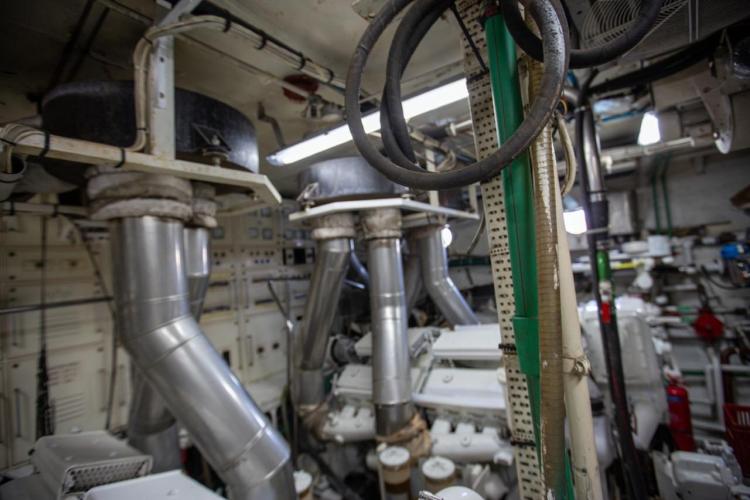 Engine room of a 1972 Benetti 33 yacht with visible pipes and machinery.