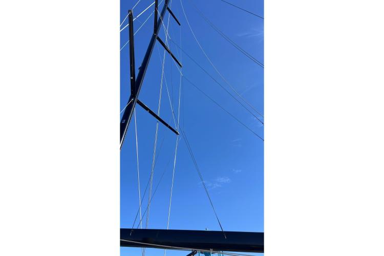 Mast and rigging of 2024 Beneteau First 53 sailboat against clear blue sky.