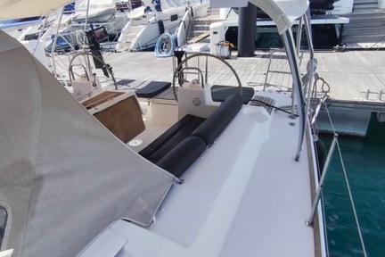2017 Dufour 460 Grand Large yacht docked at marina, featuring spacious deck and dual steering wheels.