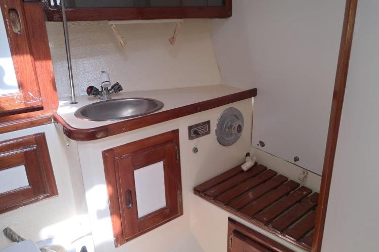 1986 Dufour CATALINA yacht interior with sink and wooden cabinetry.