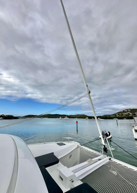 2023 Lagoon 46 catamaran on calm waters under a cloudy sky.