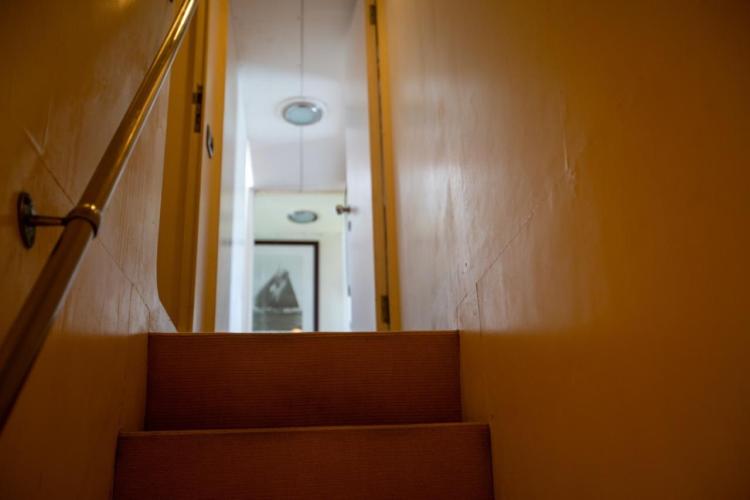 Staircase inside 1972 Benetti 33 yacht, featuring warm lighting and modern design.