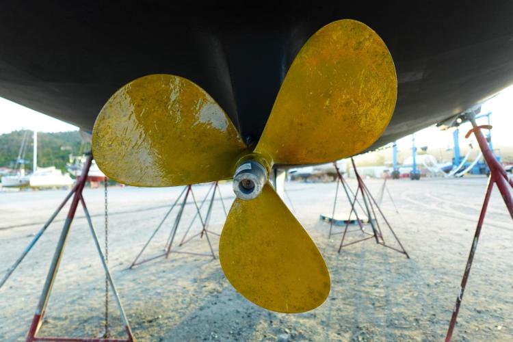 Yellow propeller of a 2005 Beneteau Cyclades 43.3 sailboat on dry dock.
