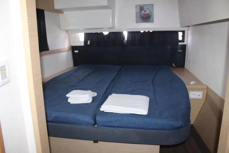Cabin interior of 2017 Fountaine Pajot SABA 50 with double bed and blue bedding.