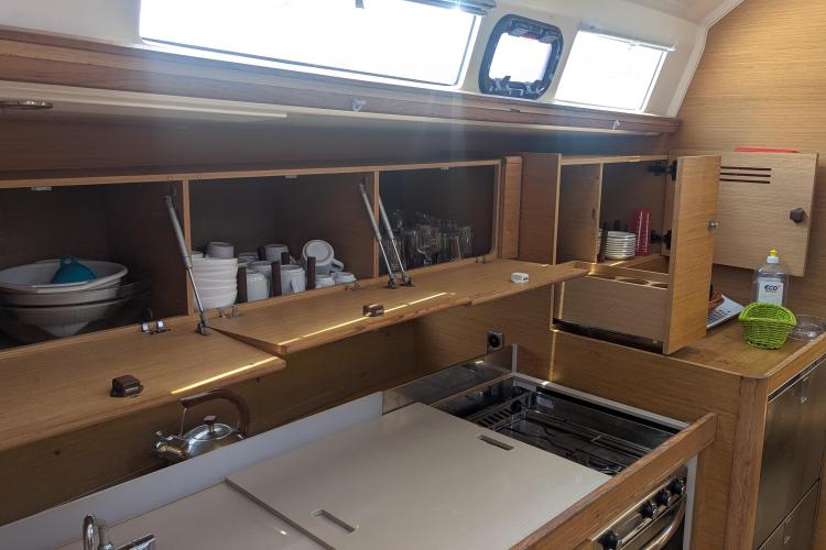 Interior of 2017 Dufour 460 Grand Large yacht kitchen with open cabinets and modern amenities.
