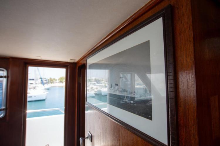 Interior of 1972 Benetti 33 yacht with framed ship photo and marina view.