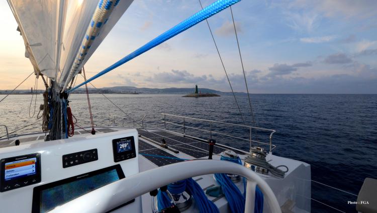Sailing on Squalt Marine CK 64 yacht, 2019 model, with ocean view and distant lighthouse.