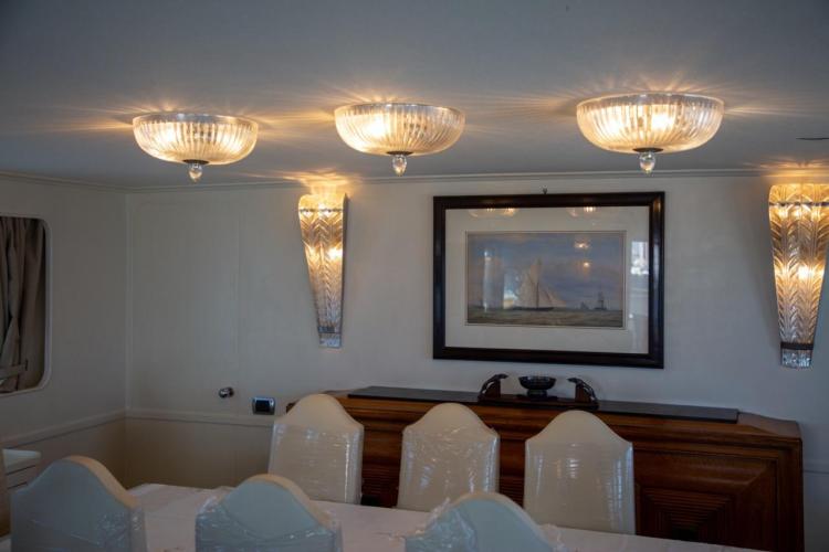 Luxurious dining area on a 1972 Benetti 33 yacht with elegant lighting and artwork.