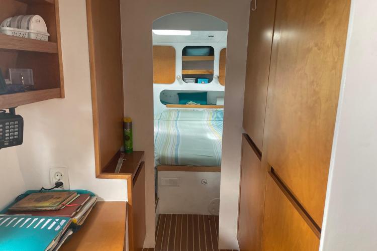 Cozy boat interior with wooden cabinets, bed, and organized shelves, Custom KSENIA 149, 2010 model.