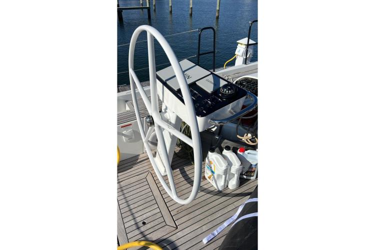 Steering wheel of 2024 Beneteau First 53 yacht on deck, with navigation equipment.