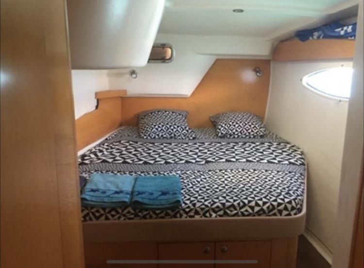 Cabin interior of 2009 Fountaine Pajot Orana 44 with patterned bedding and porthole window.