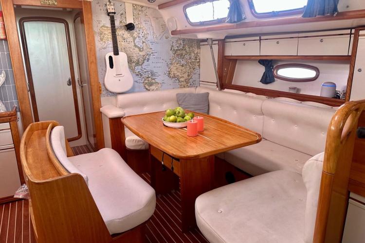 Interior of 2006 Bavaria Cruiser 46 yacht with cozy seating and nautical decor.